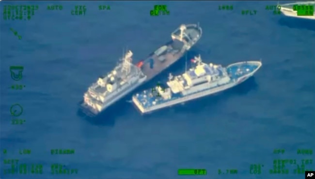 This image shows a Chinese militia vessel, top, near Philippine coast guard vessel BRP Cabra as they approach Second Thomas Shoal, at the disputed South China Sea on Sunday Oct. 22, 2023. (Armed Forces of the Philippines via AP)