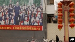 FILE — A sign features slogans calling for unity among ethnicities in Shule county in China's Xinjiang Uyghur Autonomous Region, March 20, 2021. Activists are criticizing China's law on ethnic embedding in Xinjiang as the first step in legalizing China's assimilation policies.