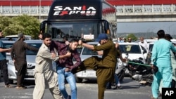 FILE - Plainclothes police officers beat a supporter of Pakistan's former Prime Minister Imran Khan during a protest to condemn the arrest of their leader in Peshawar, May 9, 2023. 