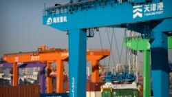 Sebuah derek mengangkat kontainer pengiriman di pelabuhan kontainer otomatis di Tianjin, China, 16 Januari 2023. (Foto: AP)