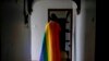 FILE - A gay Ugandan man covers himself with a pride flag as he poses for a photograph in Uganda on March 25, 2023. The U.N. Human Rights Committee condemned Uganda’s Anti-Homosexuality Act on July 26, 2023.