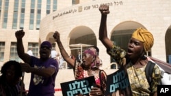 Members of the African Hebrew Israelites of Jerusalem rally outside of the District Court in Beersheba, Israel, ahead of a hearing on the deportation orders for dozens from their community, July 19, 2023.