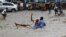 FILE - A man attempts to rescue a boy from raging floodwaters following heavy rains in Mogadishu, Somalia, Nov. 9, 2023. Farah Omar Nur, the secretary general of the Federation of Somali Journalists, says environmental journalism is not easy, especially in Somalia.