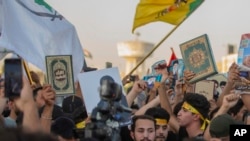 Para pengunjuk rasa Irak mengacungkan Al-Qur'an dalam demonstrasi di Lapangan Tahrir, Baghdad, Irak, Kamis, 20 Juli 2023. (Foto: (AP Photo/Adil AL-Khazali)