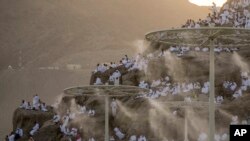 Water is sprayed on Muslim pilgrims as they pray on the rocky hill known as the Mountain of Mercy, on the Plain of Arafat, during the yearly Hajj pilgrimage, near the holy city of Mecca, Saudi Arabia.