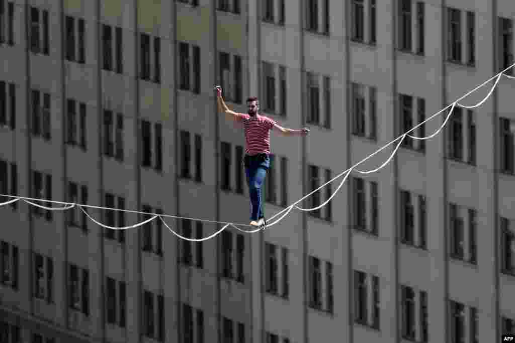 French tightrope walker Nathan Paulin crosses Alameda Avenue on a 270-meter-long taut rope, 50 meters above ground, on the opening day of the Teatro a Mil festival, in front of La Moneda Presidential Palace in Santiago.