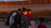 FILE - Migrants from Brazil wait to be processed by US Border Patrol agents after passing through a gap in the border wall from Mexico in Yuma, Ariz., June 10, 2021, to seek asylum. 