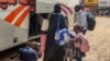 People fleeing violence load their luggage onto a bus before departure from Khartoum on May 30, 2023. The war in Sudan has caused nearly 1.4 million people to flee their homes, including more than 350,000 who have crossed into neighboring countries.