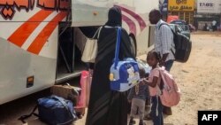 People fleeing violence load their luggage onto a bus before departure from Khartoum on May 30, 2023. The war in Sudan has caused nearly 1.4 million people to flee their homes, including more than 350,000 who have crossed into neighboring countries.