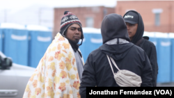 Un grupo de migrantes latinoamericanos se reúne frente a la iglesia del Sagrado Corazón a la espera de un trabajo que pueda surgir en El Paso, Texas, el 23 de enero de 2024.