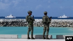 菲律宾士兵在南中国海有主权争议的中业岛上看着菲律宾海岸警卫队的船只。（2023年12月1日）