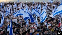 FILE - People carry Israeli flags and pictures of people believed taken hostage and held in Gaza, during a protest in Trafalgar Square, London, Oct. 22, 2023.