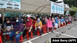 Masyarakat penerima manfaat sedang antre bansos di Jakarta, 7 Maret 2022. (Foto:Adek Berry/AFP)