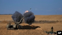 2023年10月15日，在以色列-加沙边境附近的一个阵地，一支以色列机动炮兵部队从以色列南部向加沙地带发射了一枚炮弹。