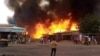 FILE — A man stands by as a fire rages in a market area in al-Fasher, North Darfur state, on Sept.1, 2023, after bombardment by the paramilitary Rapid Support Forces amid conflict with the Sudanese Armed Forces. 