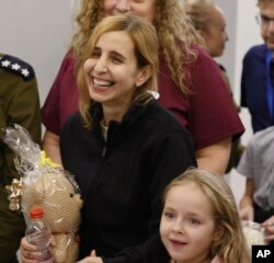 Danielle Aloni laughs next to her daughter, Emilia Aloni, as they meet relatives at a hospital in Israel, Nov. 25, 2023. The two had been seized from a kibbutz by Hamas in its Oct. 7 rampage into southern Israel. (Schneider Children's Medical Center/AP)