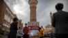 FILE - Tourists take photos in Urumqi, in Xinjiang Uyghur Autonomous Region, during a government-organized trip for foreign journalists, April 21, 2021. 