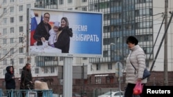 지난달 러시아 상트페테르부르크 시내 대통령 선거 광고물 앞으로 사람들이 지나가고 있다. (자료사진)