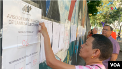 Salah seorang warga Venezuela mengamati hasil referendum tentang wilayah Essequibo dalam pemilihan pada 3 Desember 2023. (Foto: VOA) 