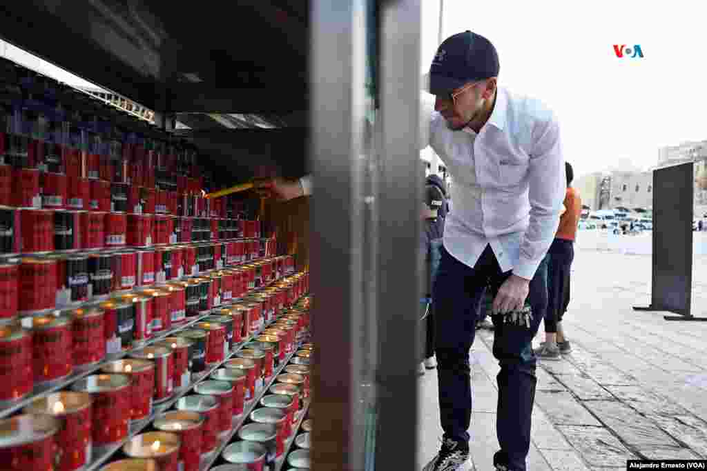 Un hombre enciende velas en homenaje a los caídos en la guerra entre Israel y Hamás.