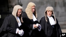 FILE - Judges cross the road toward Parliament after a Service at Westminster Abbey for the opening of the new legal year in London, Friday, Oct. 1, 2021. (AP Photo/Frank Augstein)