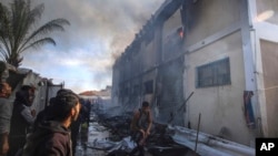 24일 가자지구 내 유엔 팔레스타인난민구호기구(UNRWA) 직업훈련센터에서 팔레스타인인들이 화재 진압을 시도하고 있다. 