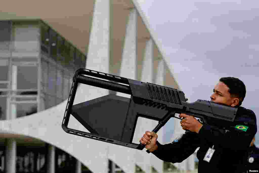 A security guard uses an anti-drone weapon against a drone that was flying near the Planalto Palace and the National Congress in Brasilia, Brazil, Jan. 8, 2024. 