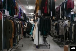 Dresses hang at the Tirelli's warehouse in Formello near Rome, Tuesday, March 5, 2024. (AP Photo/Gregorio Borgia)