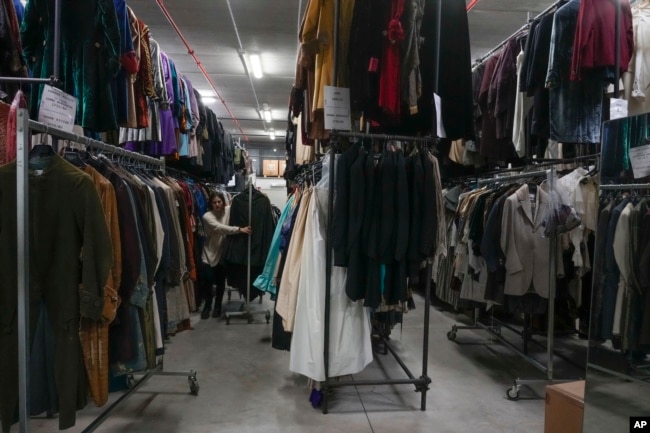 Dresses hang at the Tirelli's warehouse in Formello near Rome, Tuesday, March 5, 2024. (AP Photo/Gregorio Borgia)