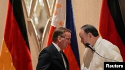 Philippine Defense Minister Gilberto Teodoro speaks with German Defense Minister Boris Pistorius as they shake hands after their joint news conference at a hotel in Makati, Metro Manila, Philippines, Aug. 4, 2024. 