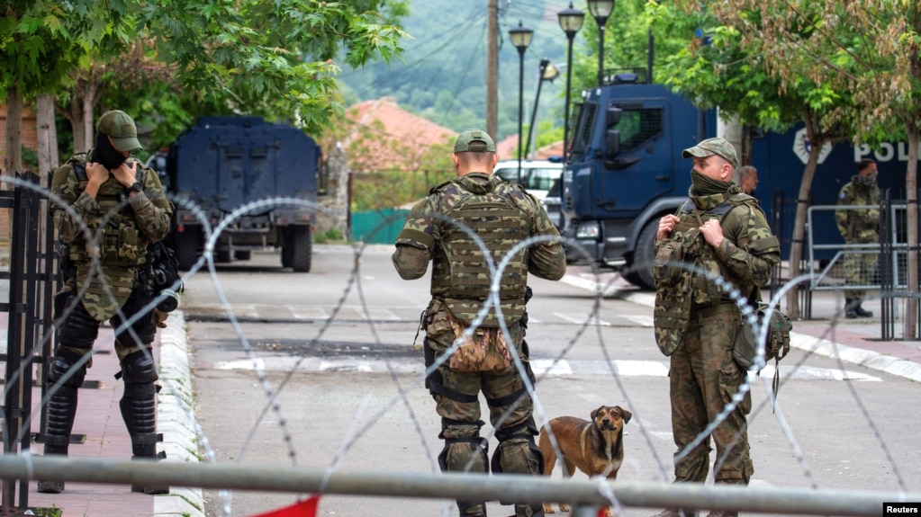 NATO Kosovo Force (KFOR) soldiers stand guard behind razor wire fence in the town of Zvecan, Kosovo, June 5, 2023.