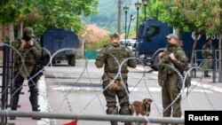 Vojnici NATO kosovskih snaga (KFOR) čuvaju stražu iza ograde od žilet žice u gradu Zvečan, Kosovo, 5. juna 2023.