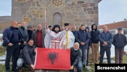 Samoproklamovani sveštenik Nikola Džufka sa grupom vernika i albanskom zastavom ispred crkve Svetog Arhangela Mihaila u albanskom selu Rakinici, u opštini Podujevo, 28. novembra 2023. 