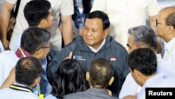 FILE - Menteri Pertahanan dan calon presiden Prabowo Subianto berbicara dengan anggota tim kampanyenya, setelah menyampaikan kebijakan antikorupsi mereka pada dialog yang diadakan di kantor pusat KPK di Jakarta, 17 Januari 2024. (REUTERS/Willy Kurniawan)