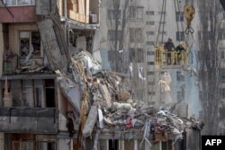 Rescuers clear debris from a multi-story building heavily damaged following a drone strike, in Odesa on March 3, 2024, amid Russia's invasion of Ukraine.