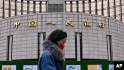 一名女子走过位于北京的中国人民银行。（2024年2月20日）