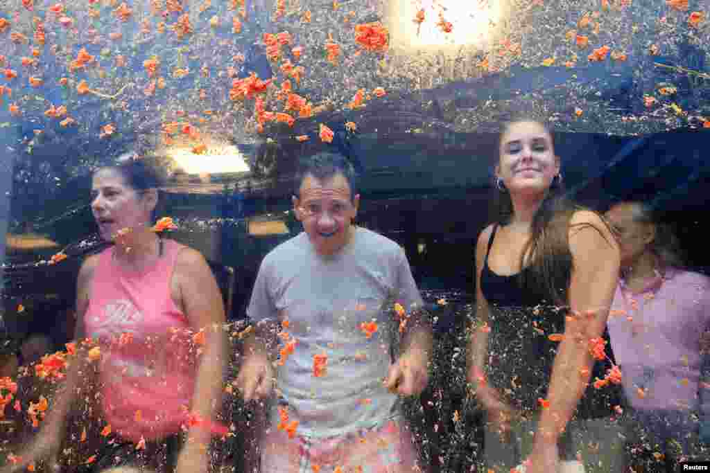 Residentes locais olham de uma janela coberta de polpa de tomate no dia do festival anual de luta de comida &ldquo;La Tomatina&rdquo; em Bunol, perto de Valência, Espanha, 28 de agosto de 2024.