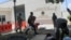 A man carries his belongings after officers of the Haitian National Police fired tear gas to clear a camp of people escaping the threat of armed gangs, in front of the US Embassy, in Port-au-Prince, Haiti, July 25, 2023.
