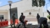 A man carries his belongings after officers of the Haitian National Police fired tear gas to clear a camp of people escaping the threat of armed gangs, in front of the US Embassy, in Port-au-Prince, Haiti, July 25, 2023.