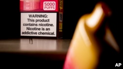 FILE — A health warning is seen on the packaging of a disposable vaping pod device in Washington, June 26, 2023.
