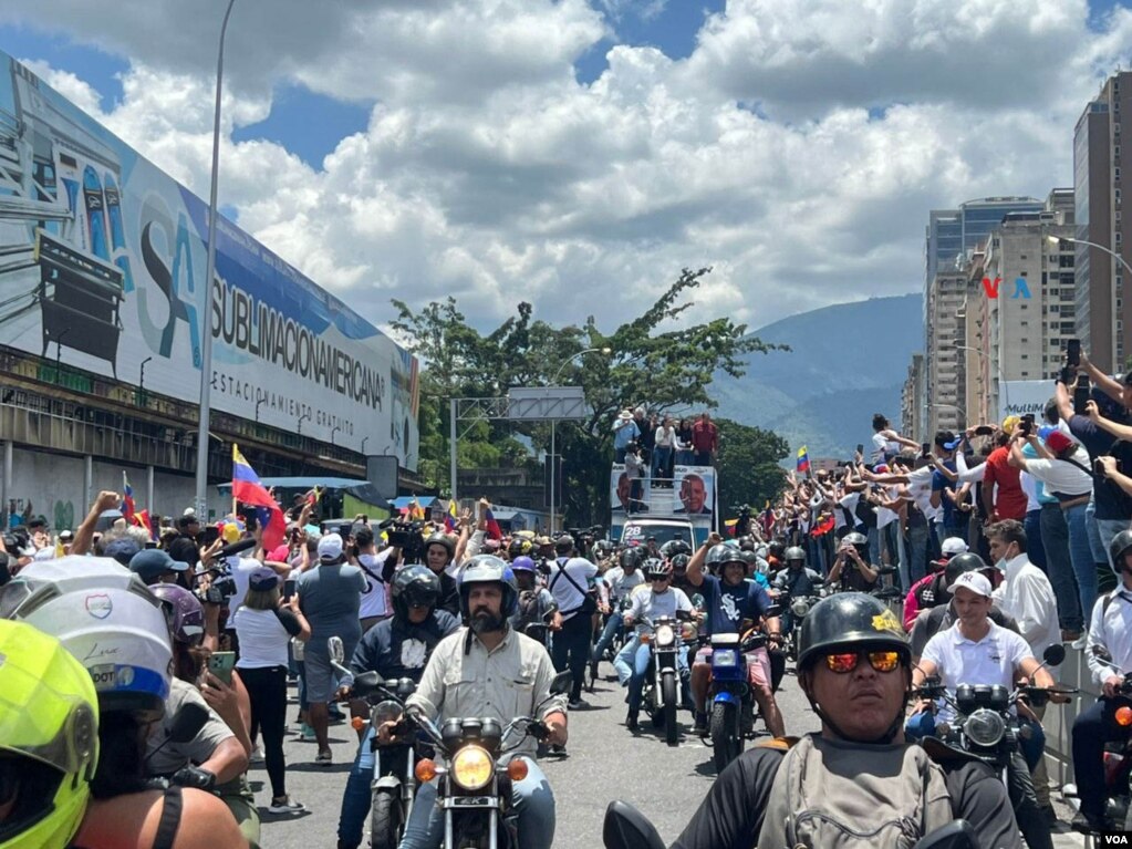 Motorizados y pueblo en general saludan a la comitiva de líderes opositores -al frente en el camión se observa a María Corina Machado- en una protesta en Caracas, Venezuela, el sábado 17 agosto de 2024. [Fotos, VOA].