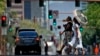 Olas de calor envuelven a dos mujeres que cruzan una calle de Phoenix, Arizona, el 17 de julio de 2023.