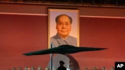 A Chinese paramilitary policeman stands guard near a portrait of Mao Zedong on Tiananmen Gate before the opening session of the National People's Congress (NPC) in Beijing, China, March 5, 2024. 