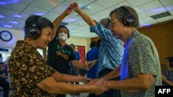 Para penderita demensia berpartisipasi dalam disko hening di Apex Harmony Lodge di Singapura, 12 Mei 2023. (Roslan RAHMAN/AFP)