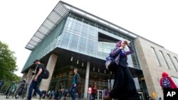 FILE - In this April 28, 2016, photo, students walk by the James Branch Cabell Library on the campus of Virginia Commonwealth University in Richmond, Va. 