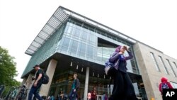 FILE - In this April 28, 2016, photo, students walk by the James Branch Cabell Library on the campus of Virginia Commonwealth University in Richmond, Va.
