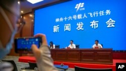 Lin Xiqiang, deputy director of the Chinese Manned Space Agency, center, speaks during a press conference at the Jiuquan Satellite Launch Center in northwest China, May 29, 2023.