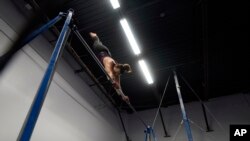 Angela Fuller, 44, works out on the high bar as she trains at 5280 Gymnastics in Littleton, Colorado, July 24, 2024.