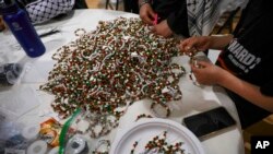 Tumpukan gelang yang hampir selesai dibuat untuk menggalang dana bagi anak-anak Palestina terlihat di sebuah meja di Masjid Dar Al Jalal di Hazelwood, Missouri, pada 2 Maret 2024. (Foto: Vanessa Abbitt/St. Louis Post-Dispatch via AP)