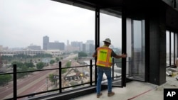 A worker opens the windows on the top floor of the new Godfrey Hotel, in Detroit, June 27, 2023.